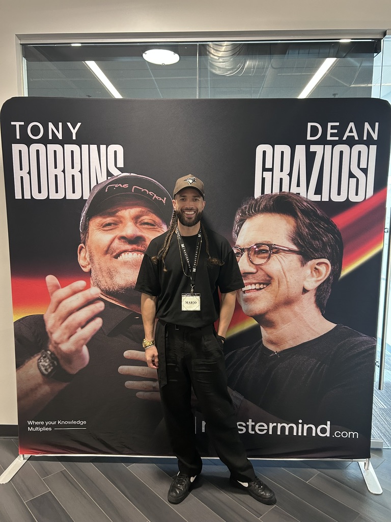 Mario Silot in front of a Tony Robbins and Dean Graziosi event backdrop
