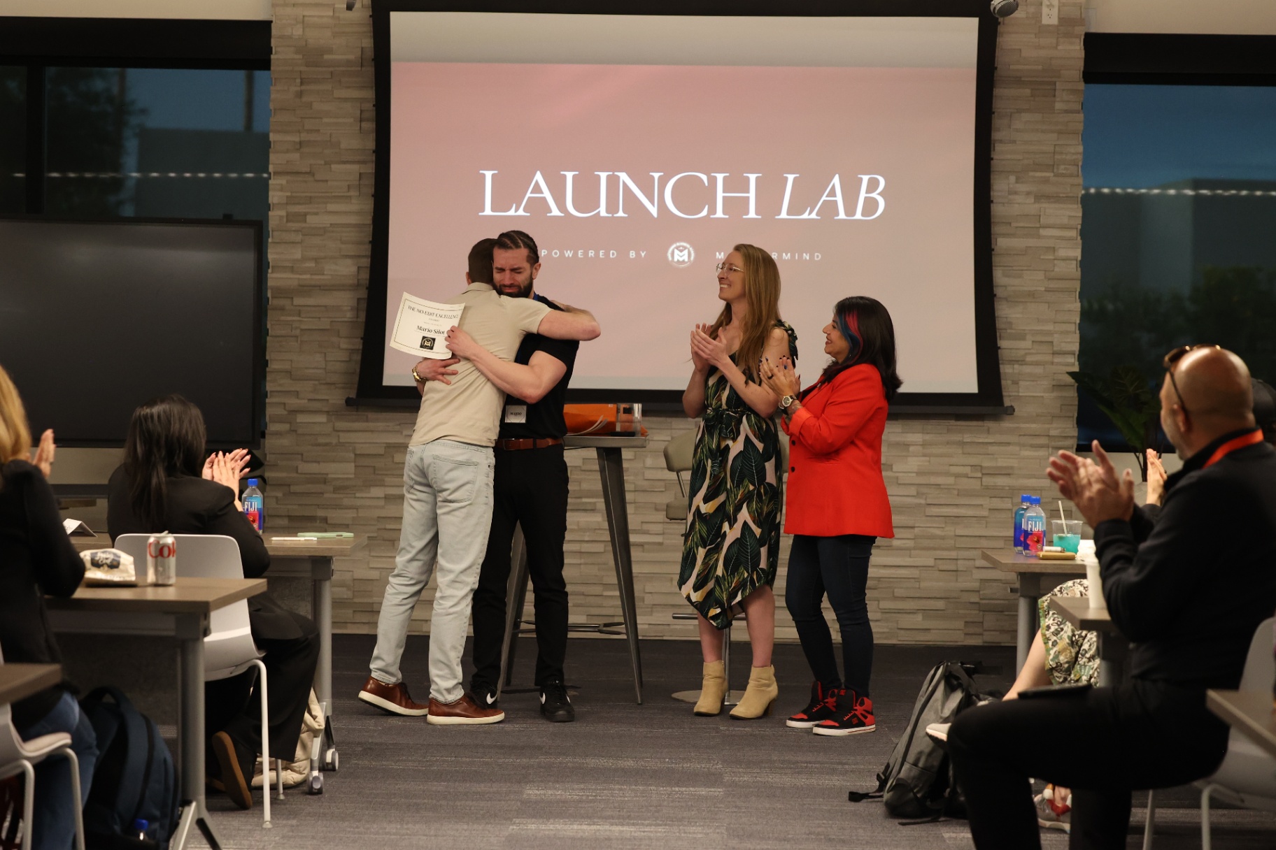 Mario Silot embracing a participant during a Launch Lab recognition moment